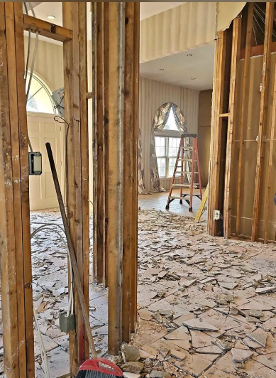 Interior gut-out with drywall removed to studs and debris cleared from the main floor