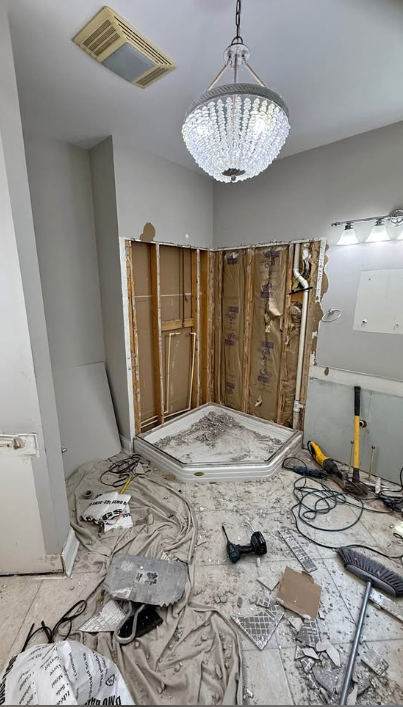 Corner shower stripped to framing during a bathroom demolition