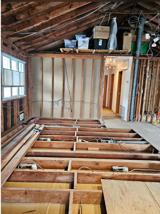 Upper floor stripped to ceiling rafters and floor joists during demolition