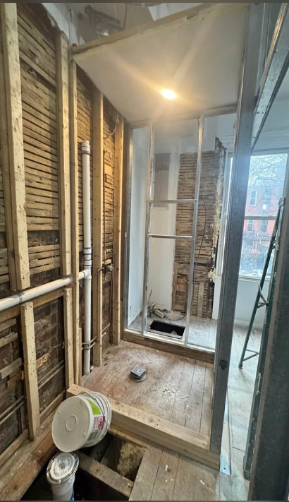 Small bathroom stripped to lath, studs and subfloor