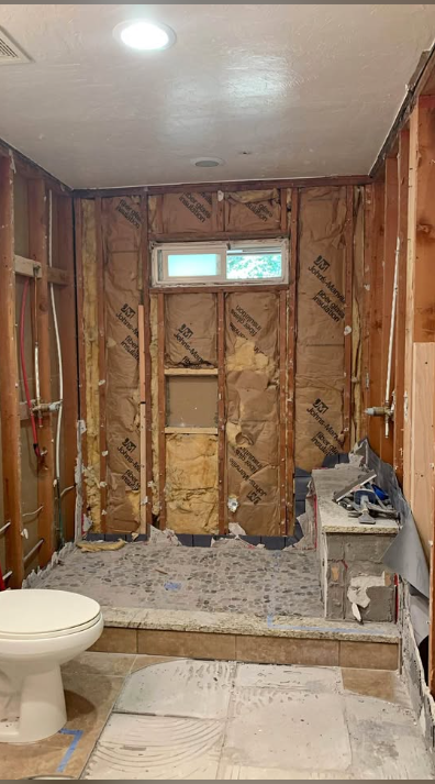 Bathroom stripped to insulation and studs with tile floor removed