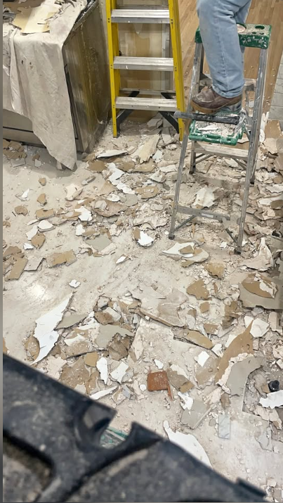 Drywall debris on the floor during a ceiling and wall removal