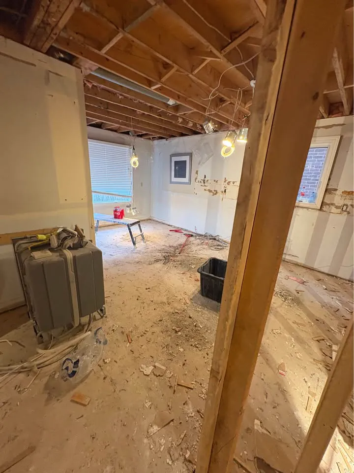 Room with the ceiling opened and parquet debris swept toward the centre