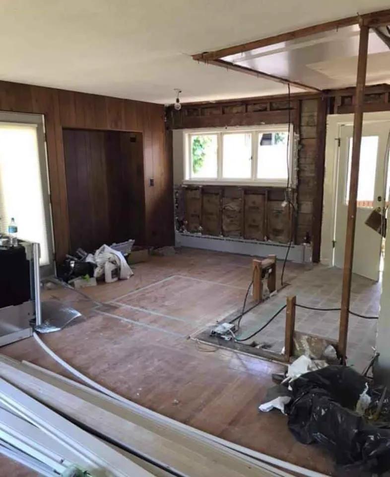 Wood-panelled room with a ceiling section removed and debris bagged