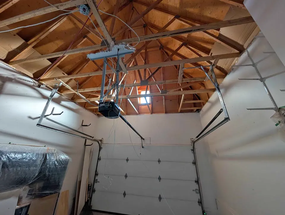 Attached garage ceiling stripped to the trusses with ductwork exposed
