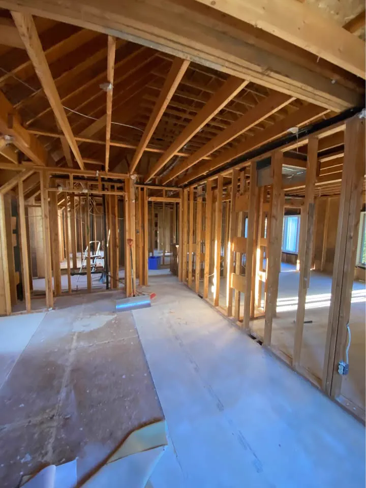 Upper floor stripped to studs and rafters with the subfloor exposed