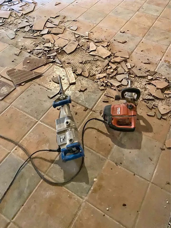 Tile floor being broken up with a demolition hammer