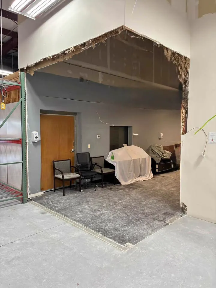 Warehouse office wall opened with the furniture on the other side covered
